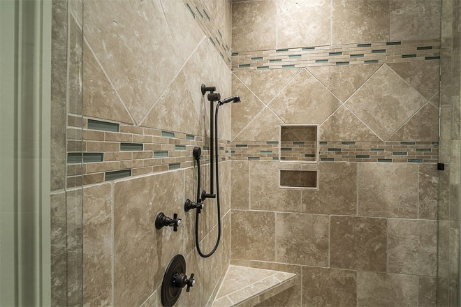 A shower with beige patterned tiles