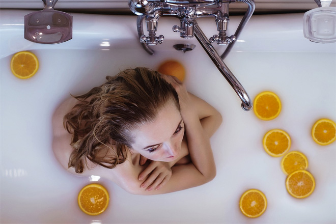 A woman in a bath with orange slices