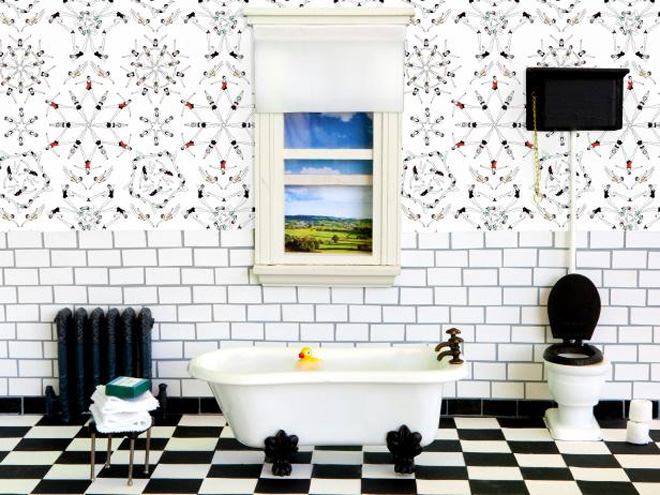 Black and white floor with a freestanding bath, white tiles and patterned wallpaper