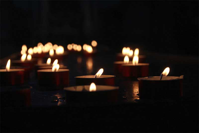 Some lighted tealight candles floating on water