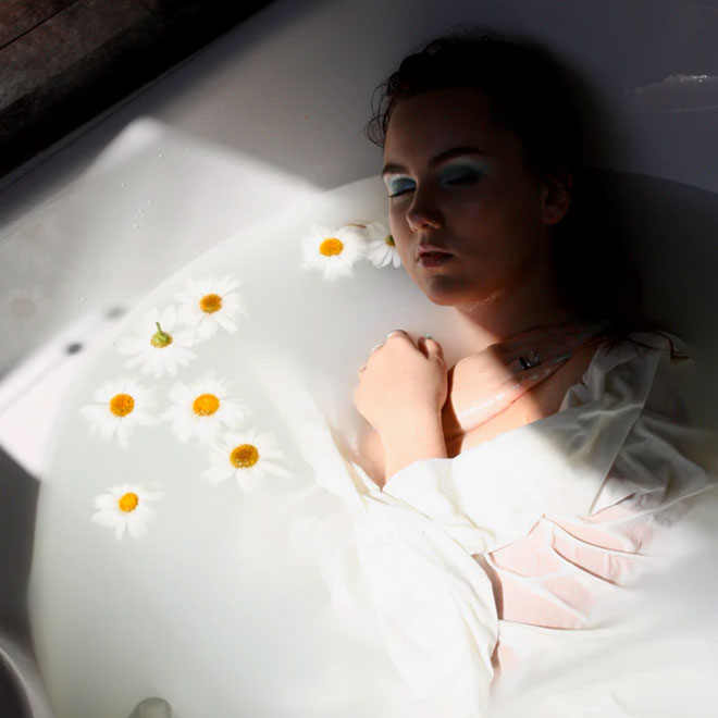 A girl relaxing in a bath with flowers