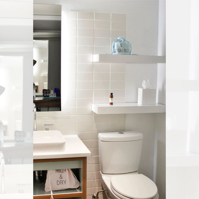 A small white bathroom with convenient shelving installed above the toilet.