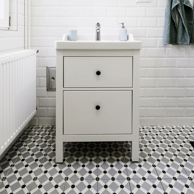 A white bathroom with patterned grey floor tiles