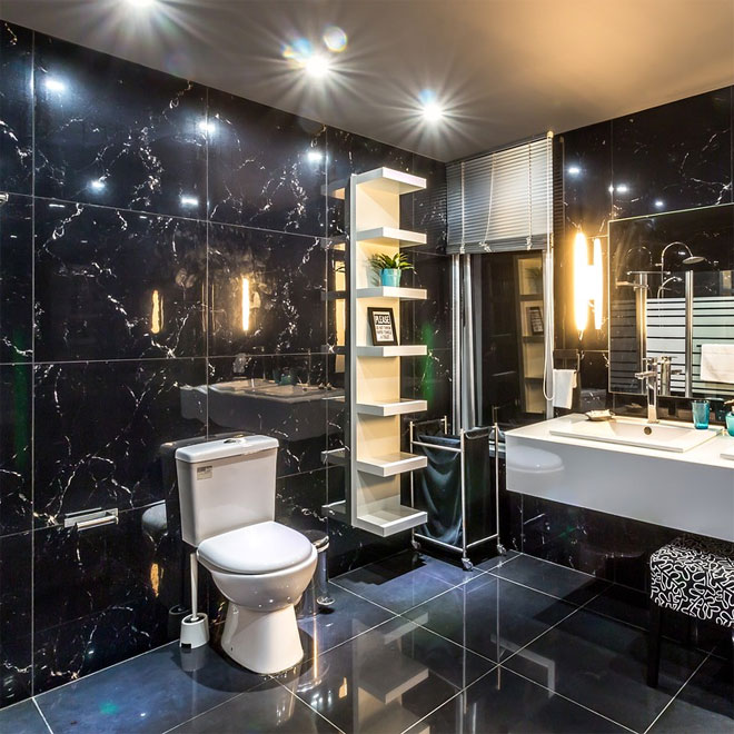 A Bathroom with shiny black tiles