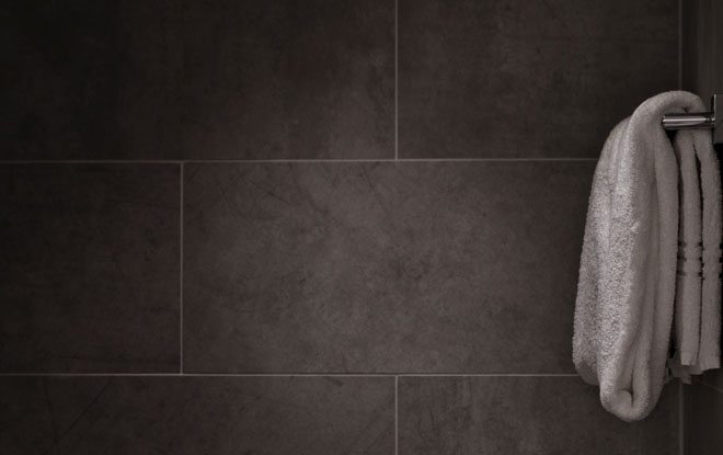 Large black tiles in a shower room