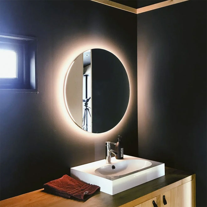 An illuminated bathroom mirror over a sink